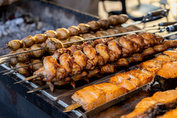 Shish kebab on skewers is fried on the grill on coals with smoke. Conceptofoutdoorrecreation.