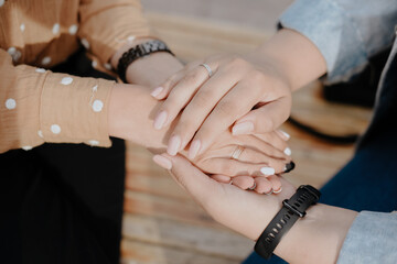 Two young adult lesbian women holding hands. Women's hands close up