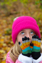 8 year old girl with colorful clothes outdoors in the forest on an october autumn day