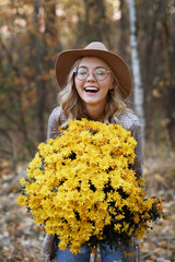 happy model with chrysanthemums in autumn