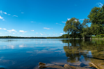 The crystal clear waters of Lake on a Mountain near Picton in Prince Edward County, Ontario glisten in the morning sun on a beautiful late summer day.