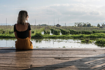 Mujer joven sentada en el lago 