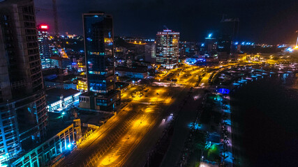 Obraz premium Road, lights and sea at night. Luanda city captured from the top