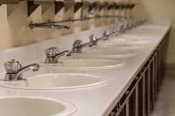 A perspective row of sinks in a bathroom (washroom or restroom) at the Diefenbunker Museum in Carp, Ontario (just outside Ottawa).