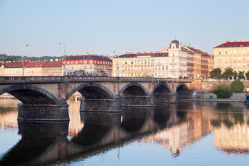View of Palacký Bridge in Prague, Czech Republic, calm morning Vltava, a tram on the bridge.
