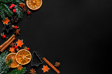 Orange slices and cinnamon sticks on a black background.Cross-zero.