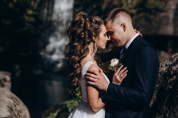 Photo session of the newlyweds against the backdrop of a picturesque area. Forest and rocks.