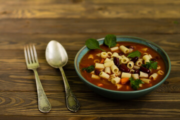Italian pasta ditalini in tomato sauce, on a wooden background