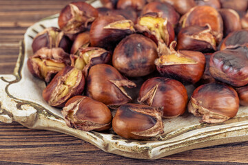 Chestnuts in a pan on a wooden background. Rustic style