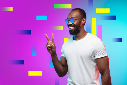 Greeting. Portrait of african-american man in bright colors. Trendy neon lighted background with copyspace for ad. Modern design. Contemporary art collage. Inspiration, mood, creativity concept.