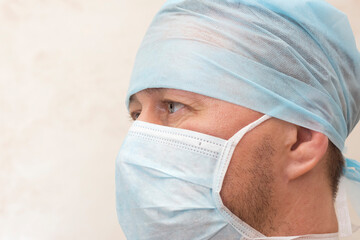 Male doctor in cap and mask close portrait