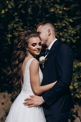 Photo session of the newlyweds against the backdrop of a picturesque area. Forest and rocks.