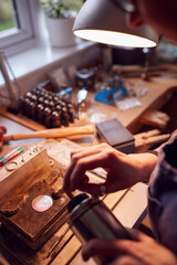 Close Up Of Male Jeweller Working On Brooch With Blowtorch In Studio