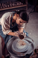 Beautiful craftsman master works with clay on a potter's wheel. Inspiration and creativity.