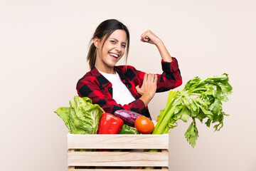 Farmer Woman holding fresh vegetables in a wooden basket making strong gesture