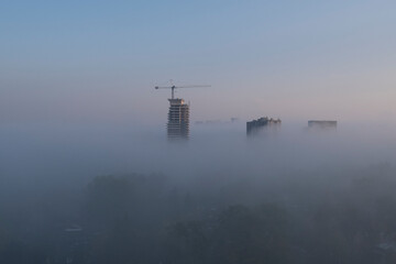 Construction crane in urban fog