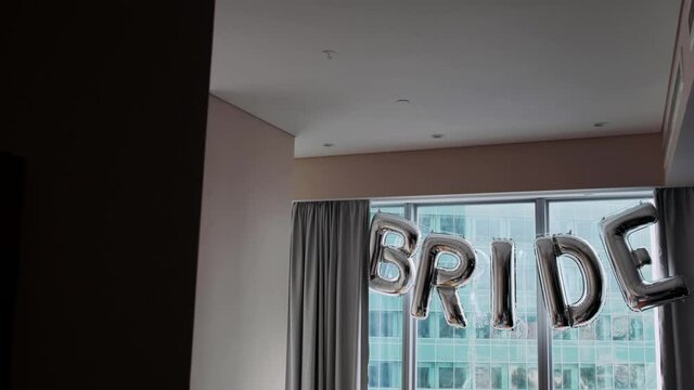 The window is decorated with balloons with the word bride