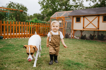 Toddler and Dog Looking at Backyard Chicken Coop © MeganBetteridge