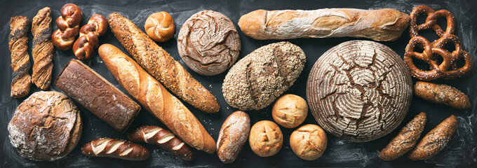 Delicious freshly baked bread assortment on dark rustic background