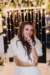 Portrait of the bride against the background of garlands. Summer evening.