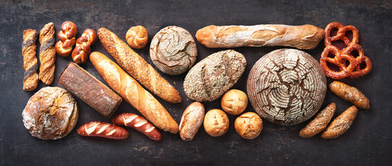 Delicious freshly baked bread assortment on dark rustic background