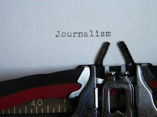 the word "journalism" typed on a typewriter, close up