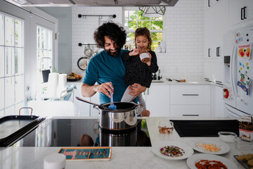 father and daughter baking holiday cookies in white kitchen
