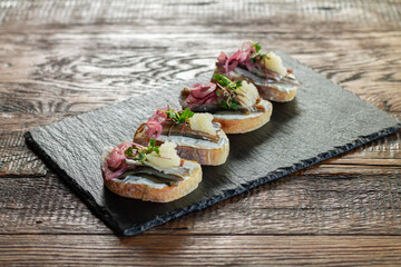 Open sandwiches with fish, cheese, onion, microgreens and caviar