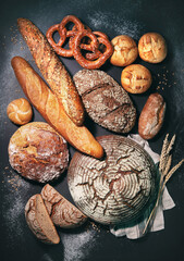 Delicious freshly baked bread assortment on dark rustic background