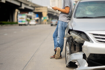 Male Motorist Involved In Car Accident Calling Insurance Company Or Recovery Service, Man roadside service after car crash.