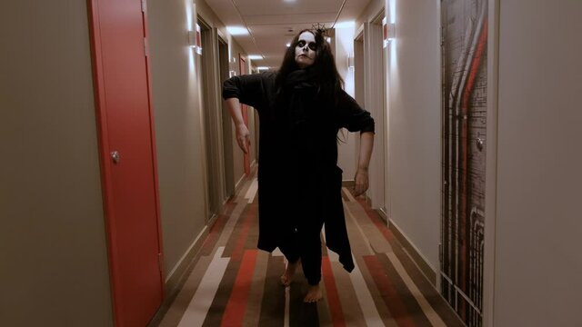 A girl with long hair, who, in the form and gait of a zombie, moves along the corridor, and then falls to the floor. Halloween Eve. October holiday.