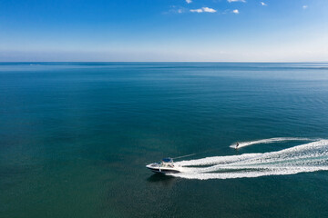 Aerial view of speedboat with wakeboard rider into the sea