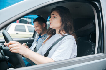 Nervous upset woman can't take driving exam. Car accident during driving lesson concept. Usatisfied male instructor notices something bad in his paper. Failed driving license exam concept.