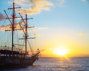 Fototapeta na wymiar Old Ship expedition at sunrise. Travel and freedom concept.