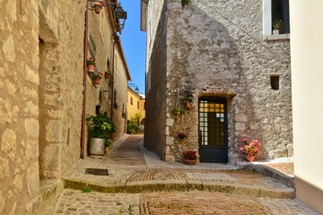 Fototapeta na wymiar A narrow street among the old stone houses of Castro dei Volsci, a medieval village in the province of Frosinone in Italy.