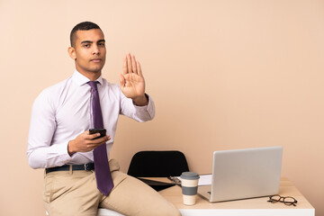 Young business man in a office making stop gesture with her hand