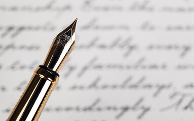 golden fountain pen with ink text background