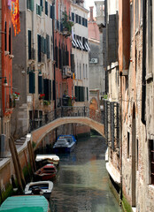 Fototapeta na wymiar Italy- Venice- Narrow Residential Canal With Boats and Bridge