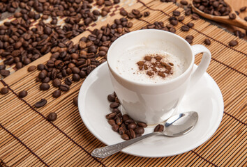 cup of coffee with froth on a bamboo napkin still life