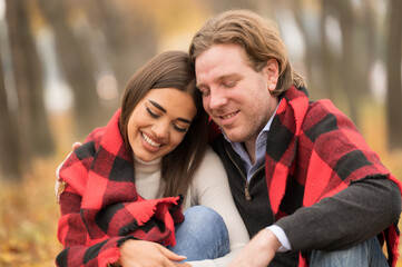Happy couple having picnic in a park, fall season