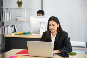asian lady employee working with laptop