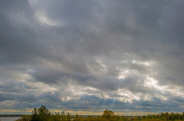 The edge of a lake in autumn colors under a cloudy sky at fall, Almere, Flevoland, The Netherlands, October 26, 2020