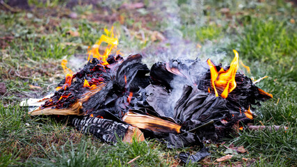 Burning books on a fire spread out on the grass