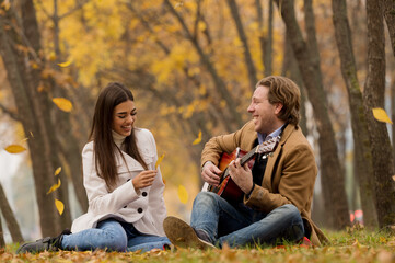 Happy couple having picnic in a park, fall season