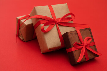 Christmas gifts in boxes tied with red ribbons, isolated on red background