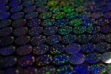 Sequins close-up macro. Abstract background with blue sequins and lilac color on the fabric. Texture scales of round sequins with color transition.