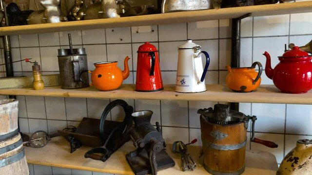 Old And Vintage Coffee Grinders With Coffee Pots Display On The Wooden Shelves. - panning shot