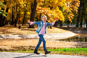Happy little girl in an autumn park