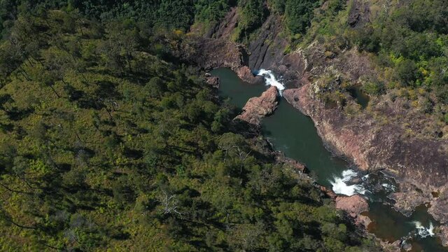 River cascading down gorge before waterfall drop, aerial arc shot