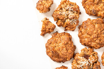 Lots of homemade oatmeal cookies with a various nuts and sesame seeds on a white background top view. Free space for text. Oatmeal cookies background. Copy space
